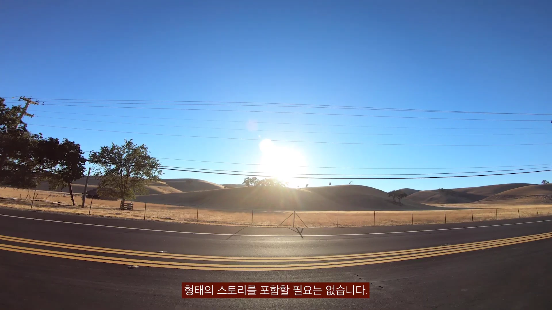 햇살이 비치는 노란 언덕과 도로가 펼쳐진 야외 풍경 영상에 '형태의 스토리를 포함할 필요는 없습니다.'라는 한글 자막이 표시되어 있습니다.