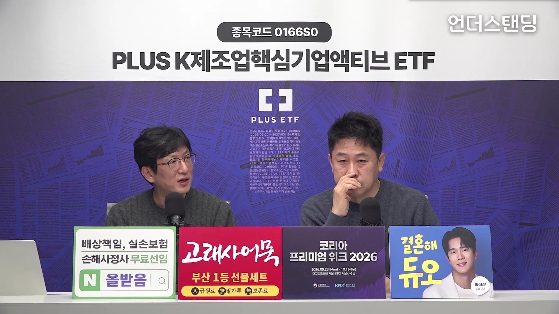 두 명의 남성이 책상 앞에 앉아 마이크를 앞에 두고 대화를 나누고 있는 스튜디오 현장입니다. 화면 뒤편에는 특정 기업의 ETF 상품명이 크게 적혀 있고, 책상 위에는 상품 광고 문구가 적힌 여러 개의 패널이 놓여 있습니다.