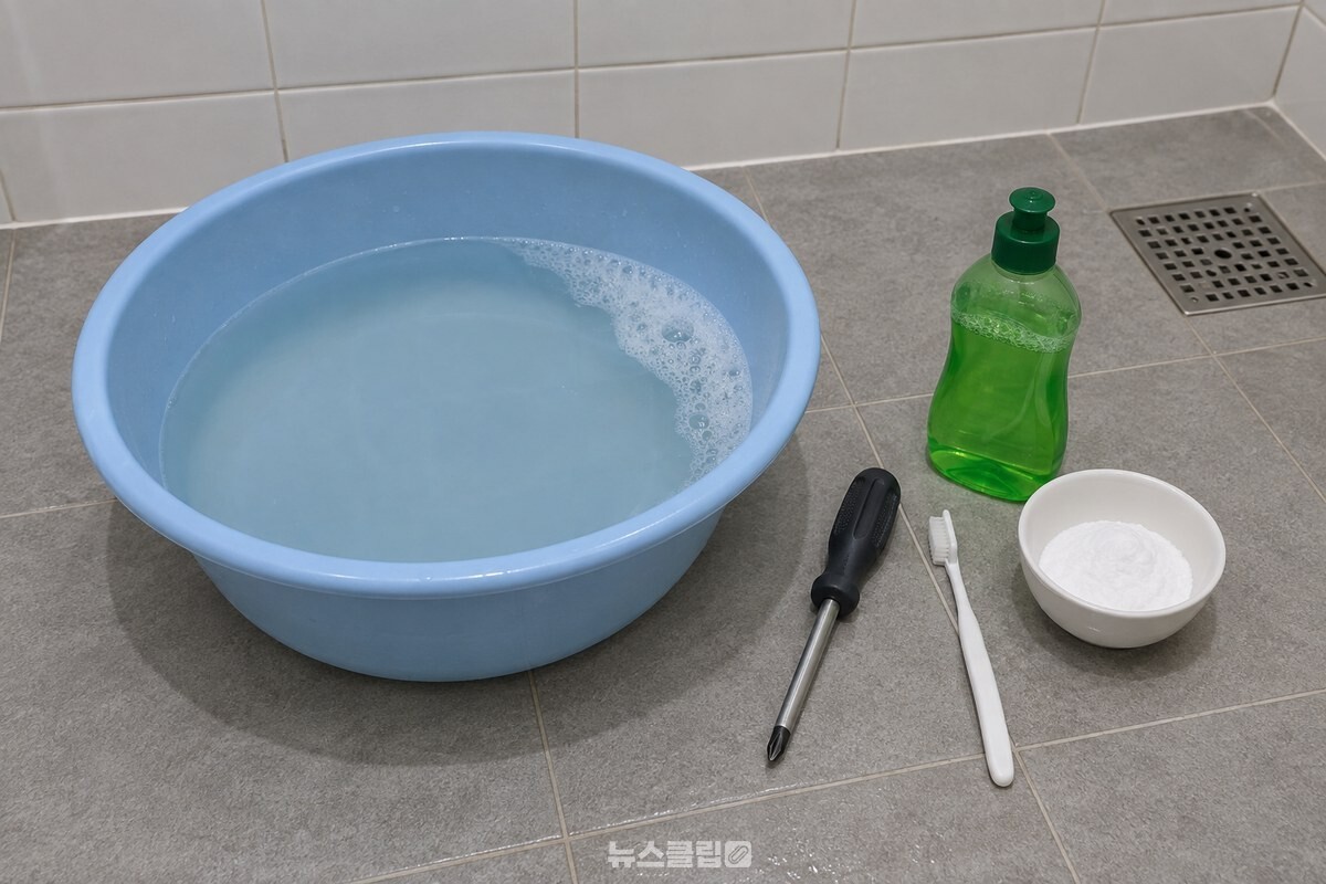 욕실 바닥에 놓인 대야에 미지근한 물을 받고 옆에 십자드라이버와 칫솔, 베이킹소다와 주방 세제를 둔 모습. / 기사 이해를 돕기 위한 생성형 이미지