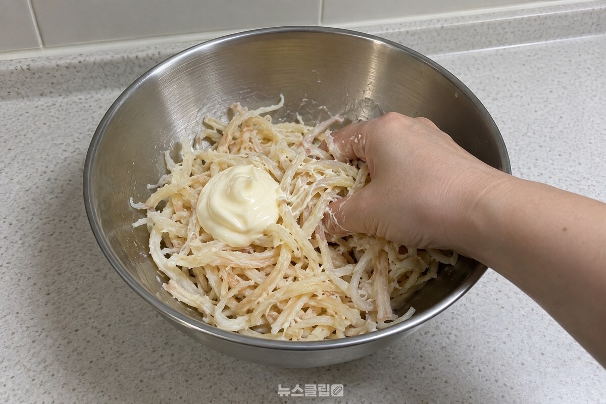 물기를 짠 진미채가 담긴 볼에 마요네즈 한 큰술을 올리고 손으로 버무리기 시작한다. / 기사 이해를 돕기 위한 생성형 이미지