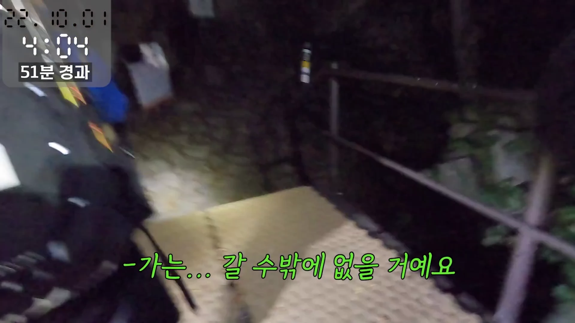 새벽 시간대 어두운 등산로를 따라 계단을 오르는 시점에서 촬영된 1인칭 시점의 영상 화면입니다.
