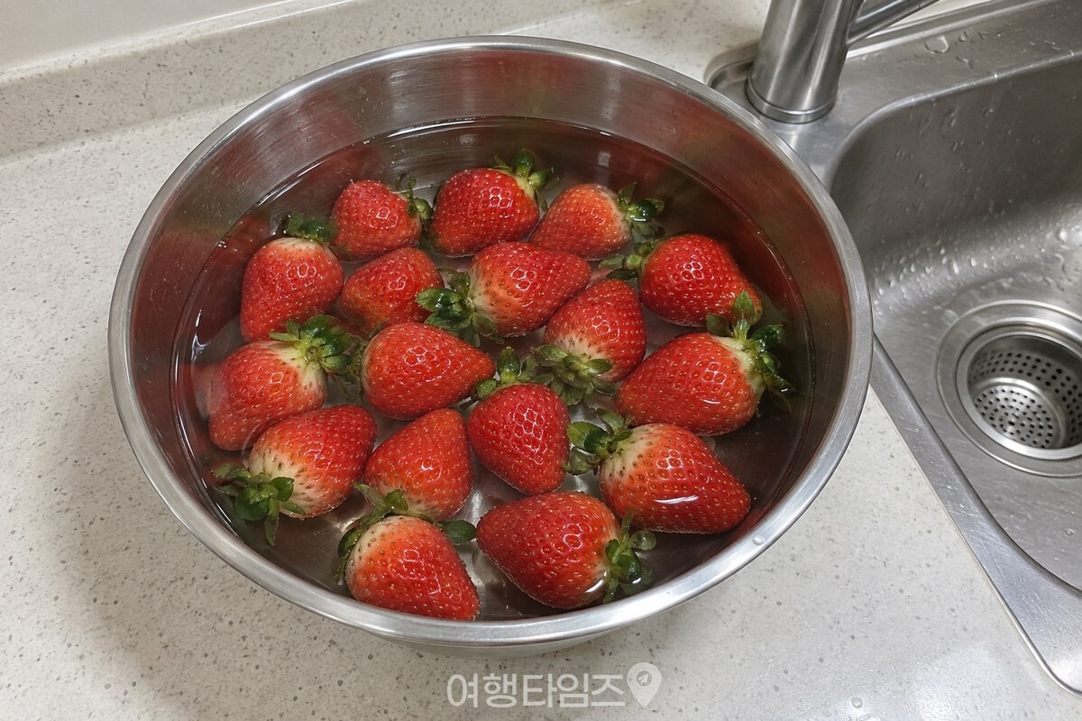 스테인리스 볼에 받은 맹물에 딸기가 완전히 잠겨 있고, 옆에 아무것도 타지 않은 상태로 그대로 두었다. / 기사 이해를 돕기 위한 생성형 이미지