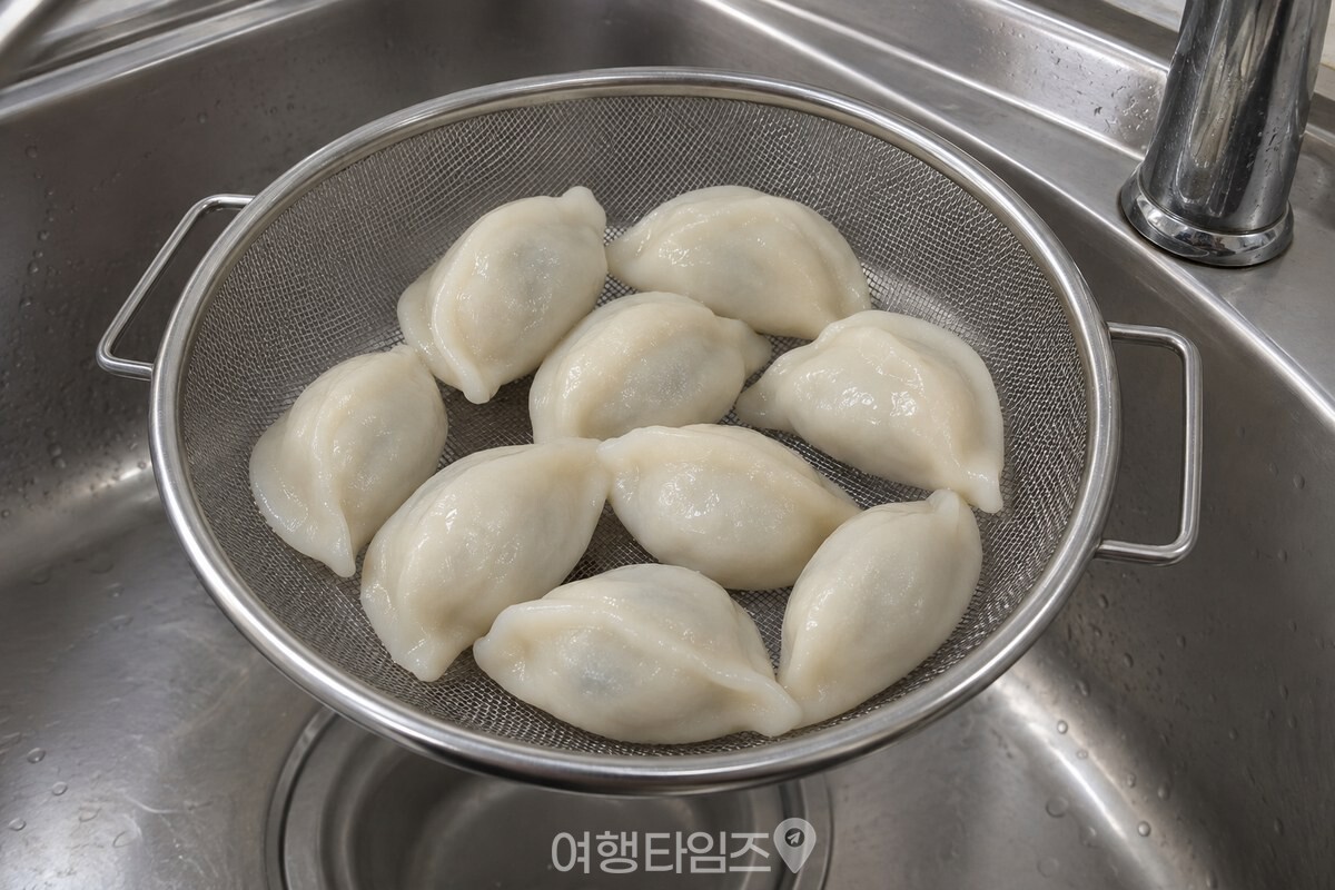 찜기에서 꺼낸 송편 몇 알이 체 위에서 가까이 붙어 있는 모습 / 기사 이해를 돕기 위한 생성형 이미지