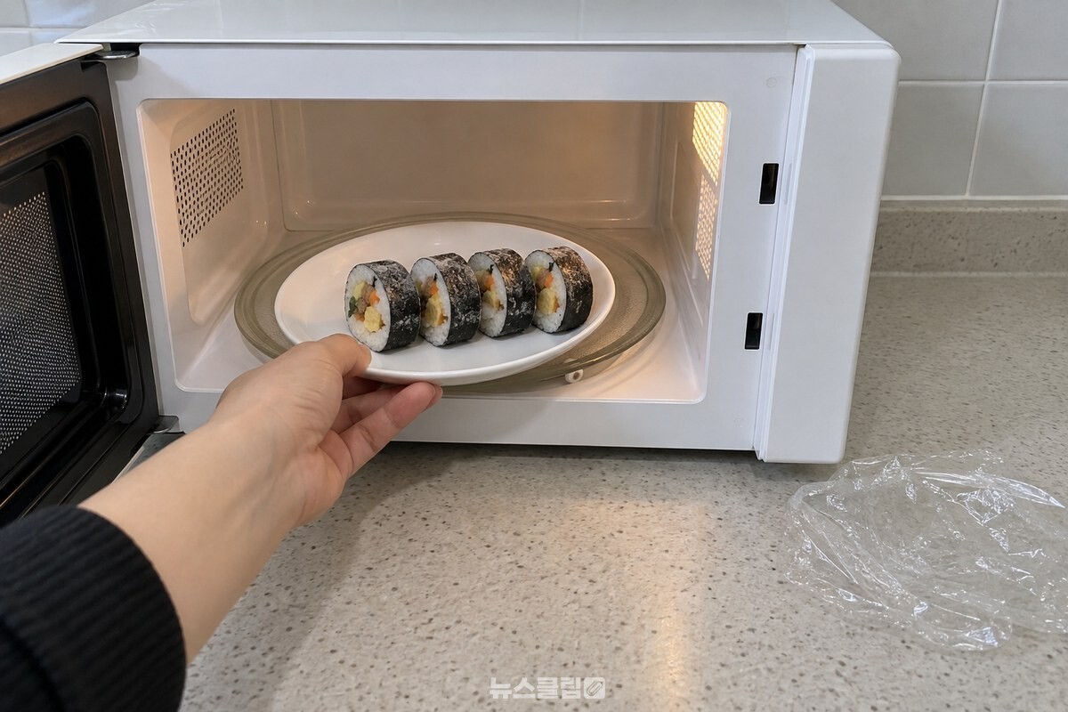 랩을 벗겨 접시에 담은 김밥 네 조각을 전자레인지 안에 넣는 모습. / 기사 이해를 돕기 위한 생성형 이미지