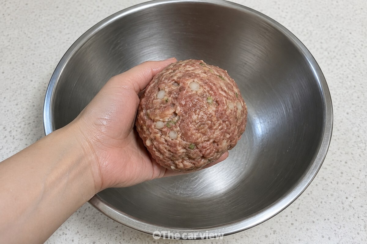 한 덩어리로 뭉친 떡갈비 반죽을 볼 안에서 손으로 들어 올린 모습. / 기사 이해를 돕기 위한 생성형 이미지