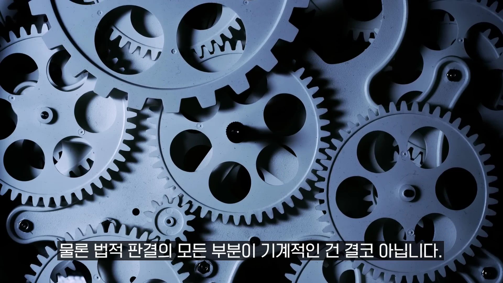 서로 맞물려 돌아가는 회색 톱니바퀴들이 화면 전체에 가득 찬 근접 촬영 이미지.