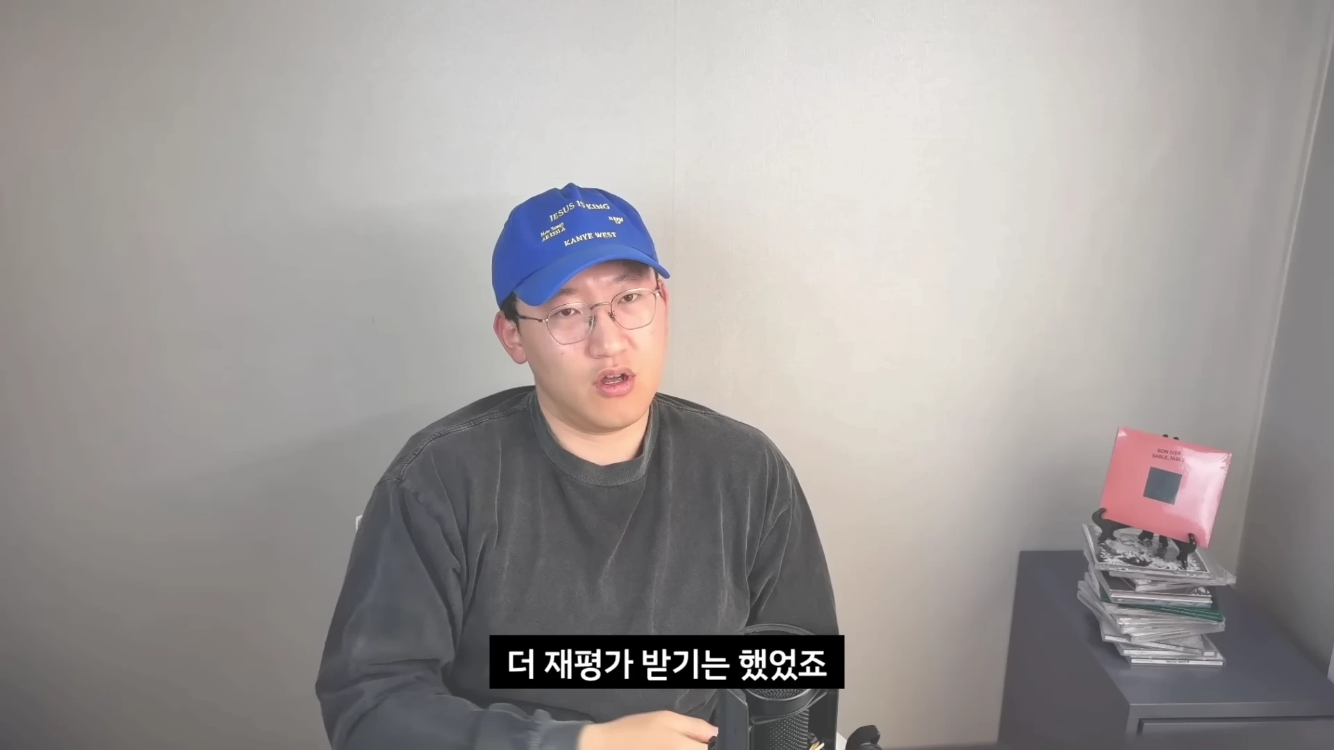 안경을 쓰고 파란색 볼캡을 쓴 남성이 마이크 앞에서 이야기를 나누고 있는 모습이 담긴 유튜브 영상 화면입니다.