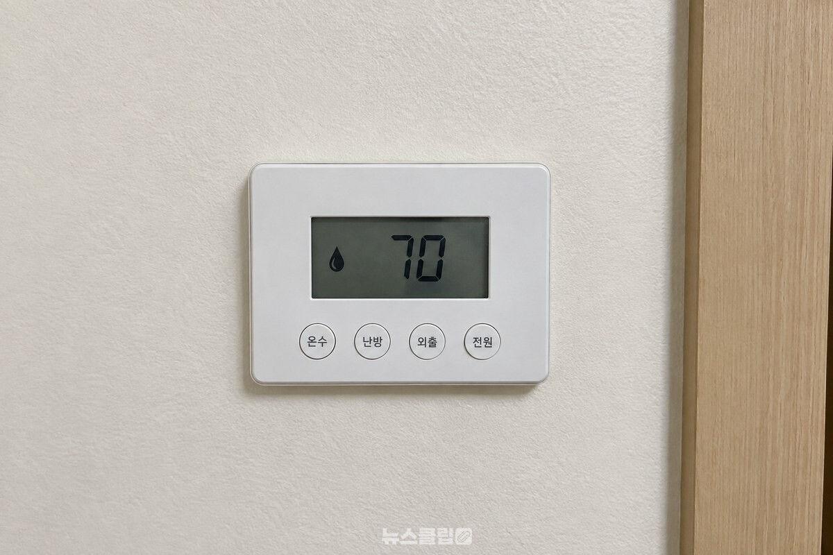 거실 벽에 붙은 보일러 온도조절기 화면에 온수 설정 숫자 70이 떠 있다. / 기사 이해를 돕기 위한 생성형 이미지