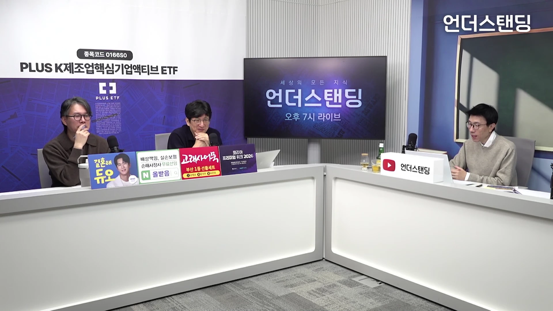 세 명의 출연자가 스튜디오 테이블에 앉아 대화를 나누고 있는 모습이 담긴 방송 화면입니다.