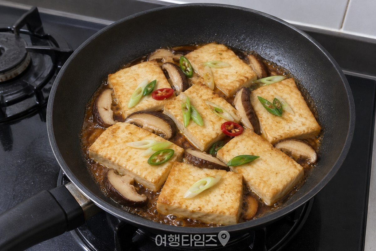 다 조려진 두부조림이 팬 안에 그대로 담겨 있고, 두부 사이사이에 썬 표고버섯과 자작한 국물이 보인다. / 기사 이해를 돕기 위한 생성형 이미지