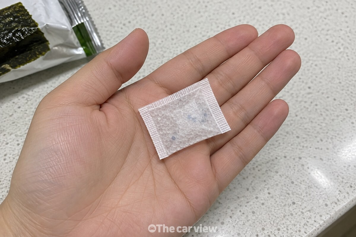김 봉지에서 꺼낸 작은 실리카겔 방습제를 손바닥 위에 올려 둔 모습. / 기사 이해를 돕기 위한 생성형 이미지