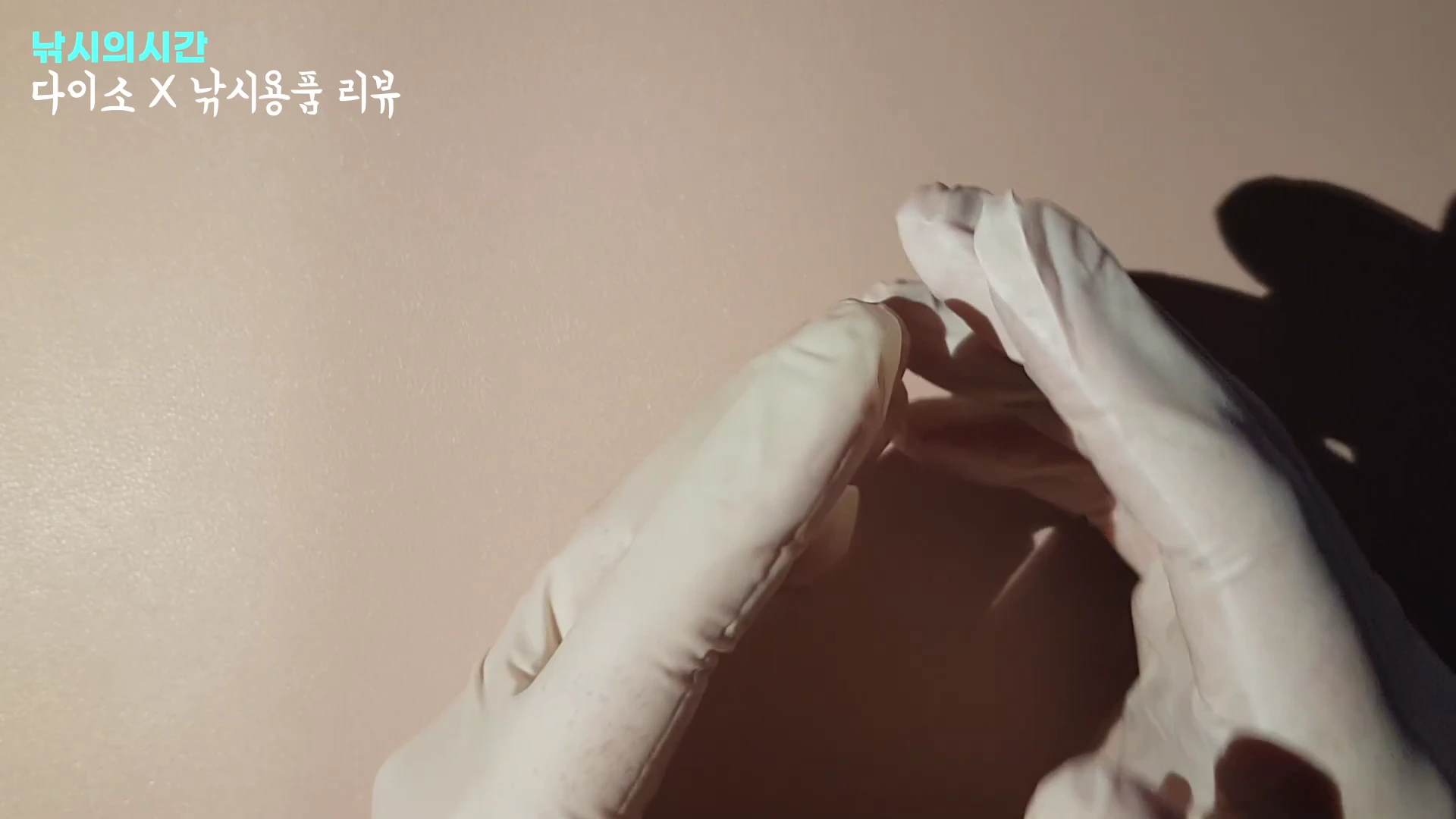 흰색 일회용 니트릴 장갑을 낀 두 손이 화면 중앙에서 서로 맞닿아 있는 모습