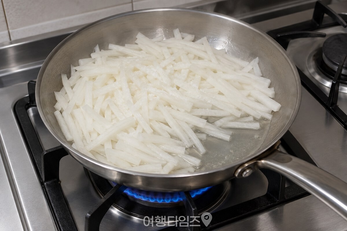 소금만 넣고 볶은 흰 무채에서 물이 빠져나와 팬 바닥 한쪽에 얕게 고여 있다. / 기사 이해를 돕기 위한 생성형 이미지