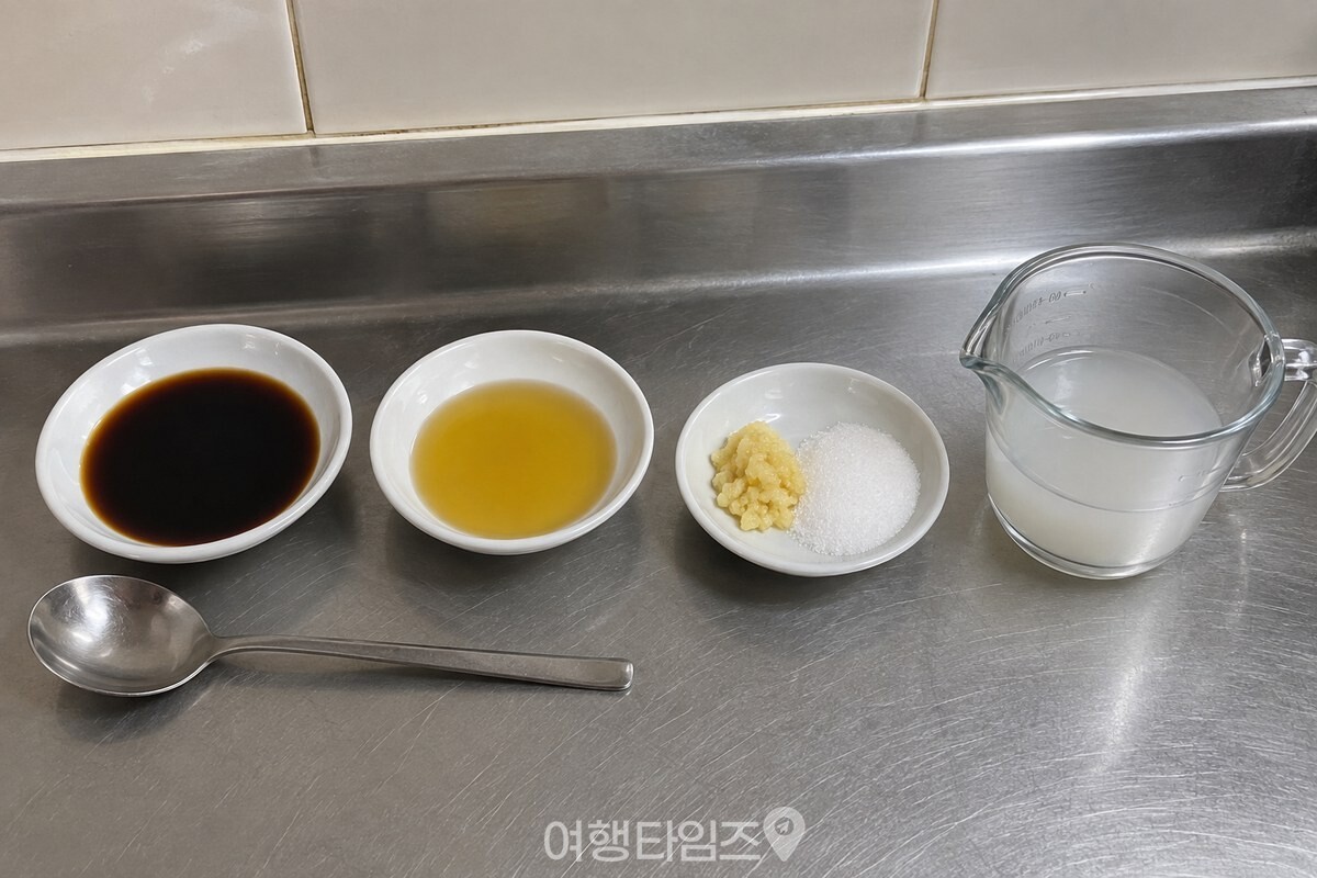 무나물에 쓸 진간장 3스푼과 들기름, 간 마늘, 설탕, 쌀뜨물을 조리대에 나란히 준비해 뒀다. / 기사 이해를 돕기 위한 생성형 이미지