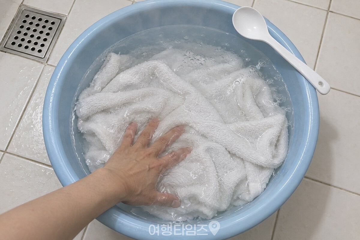 따뜻한 물을 받은 대야에 과탄산소다를 풀어 잔거품이 올라오고 수건을 펼쳐 담그고 있다. / 기사 이해를 돕기 위한 생성형 이미지