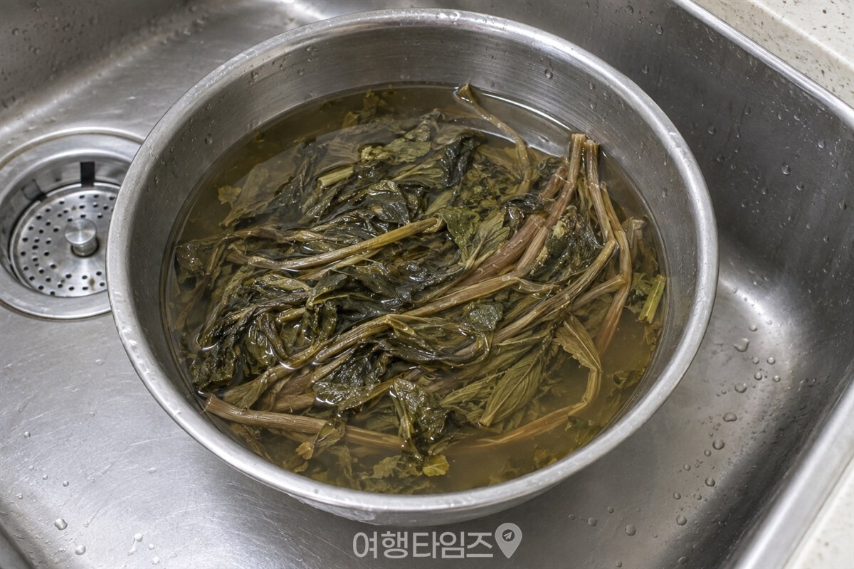 미지근한 물을 담은 스테인리스 볼에서 마른 취나물이 불어 잎이 펴진 상태. / 기사 이해를 돕기 위한 생성형 이미지