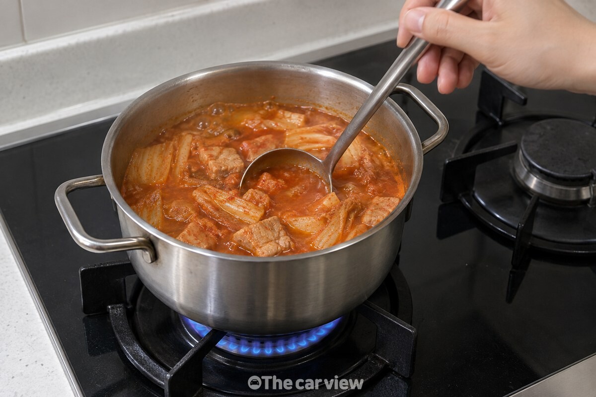 국자로 저어 케첩이 국물에 고르게 풀리는 김치찌개 / 기사 이해를 돕기 위한 생성형 이미지