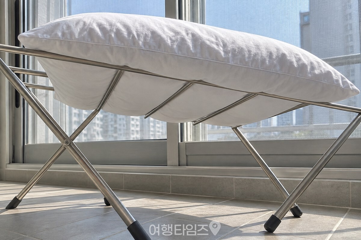 볕이 드는 위쪽 면과 건조대 그늘에 가린 아래쪽 면이 함께 보이도록 낮은 각도에서 본 베개솜. / 기사 이해를 돕기 위한 생성형 이미지