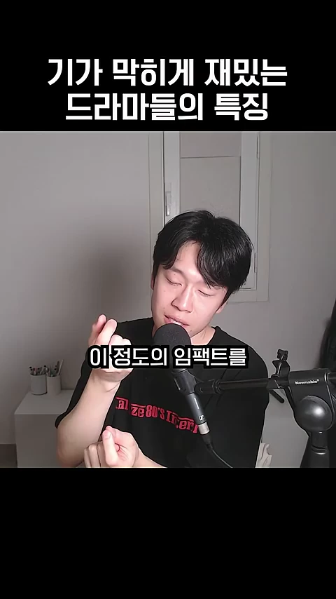 검은색 티셔츠를 입은 남성이 마이크 앞에 앉아 양손으로 무언가를 묘사하는 듯한 동작을 하고 있으며, 화면 상단에는 '기가 막히게 재밌는 드라마들의 특징'이라는 자막이 적혀 있다.