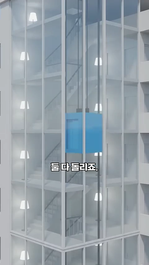 투명한 벽면과 계단이 보이는 아파트 구조물 중앙에서 파란색 승강기가 작동하는 모습이 담긴 3D 그래픽 영상 화면. 화면 중앙에 '둘 다 돌리죠.'라는 한국어 자막이 적혀 있다.