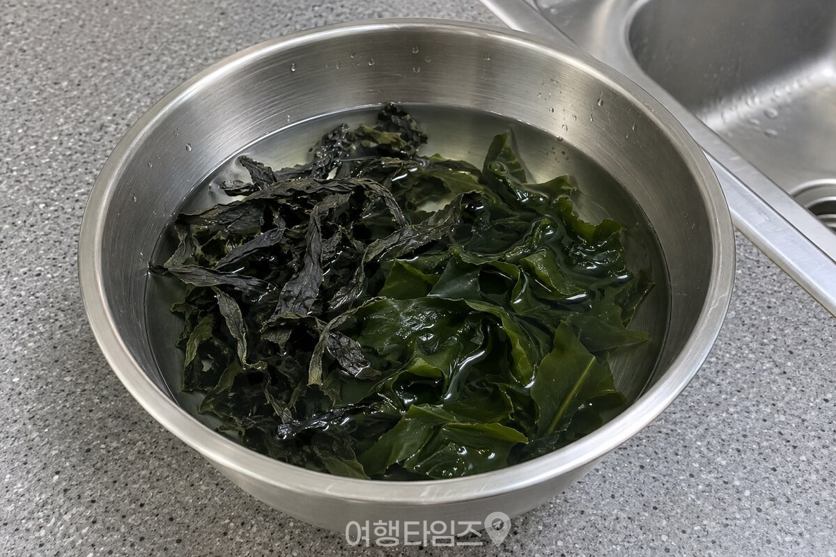 찬물을 부은 스테인리스 볼 안에서 마른미역 한 줌이 풀리기 시작한 모습. / 기사 이해를 돕기 위한 생성형 이미지