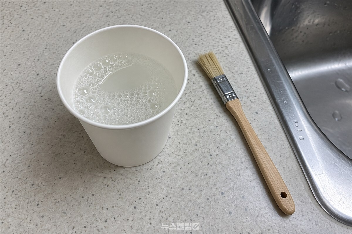물과 주방세제를 섞은 작은 종이컵과 점검용 붓을 준비한 모습. / 기사 이해를 돕기 위한 생성형 이미지