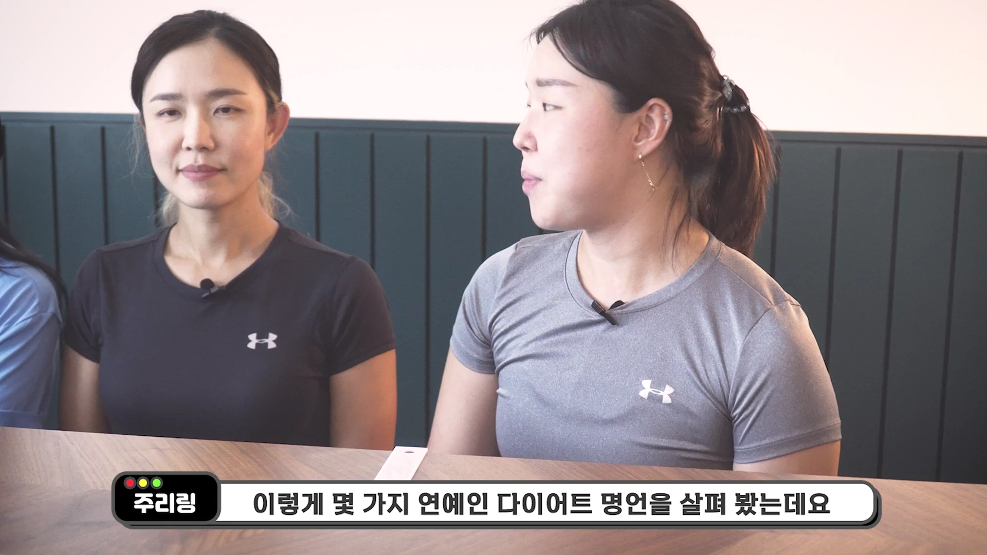 실내에서 운동복을 입은 두 여성이 대화를 나누고 있으며, 화면 하단에는 자막이 떠 있습니다.