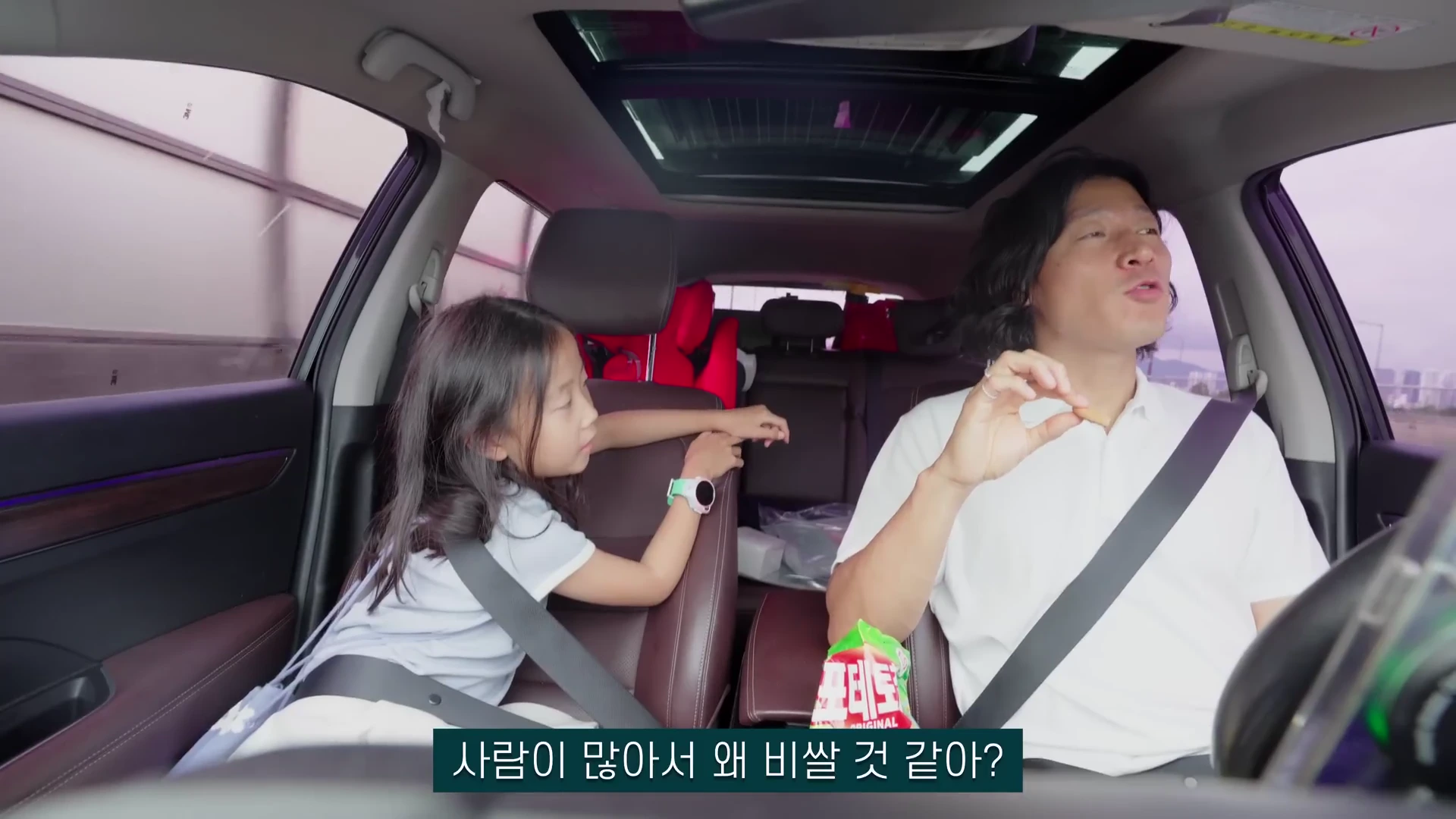차 안 조수석과 운전석에 앉은 어린 딸과 아빠가 서로를 바라보며 대화를 나누고 있고, 화면 하단에는 자막이 떠 있습니다.