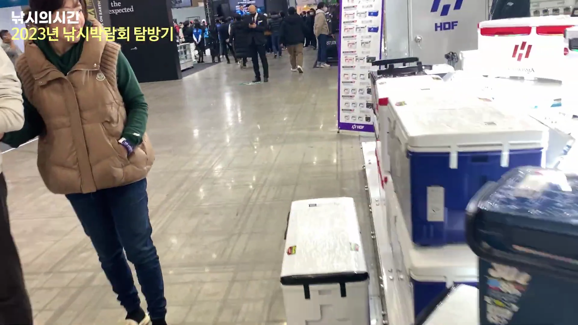 일산 킨텍스 낚시박람회 현장에서 낚시용 아이스박스와 쿨러가 진열된 매대를 구경하는 사람들의 모습.