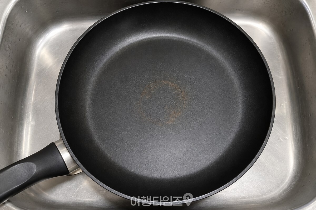 코팅 팬 바닥 중앙에 얇게 남은 갈색 눌은 자국을 가까이에서 보여 주는 모습. / 기사 이해를 돕기 위한 생성형 이미지