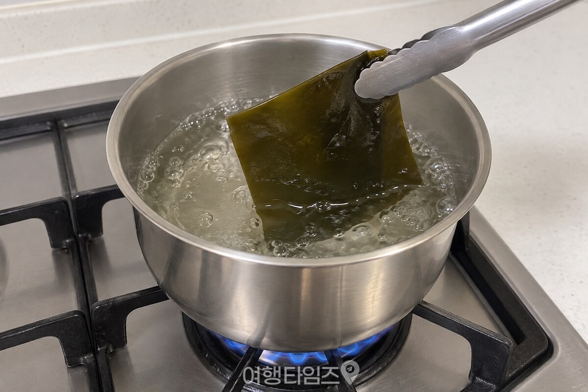 끓기 시작한 냄비에서 다시마 한 장을 집게로 건져 내는 모습. / 기사 이해를 돕기 위한 생성형 이미지