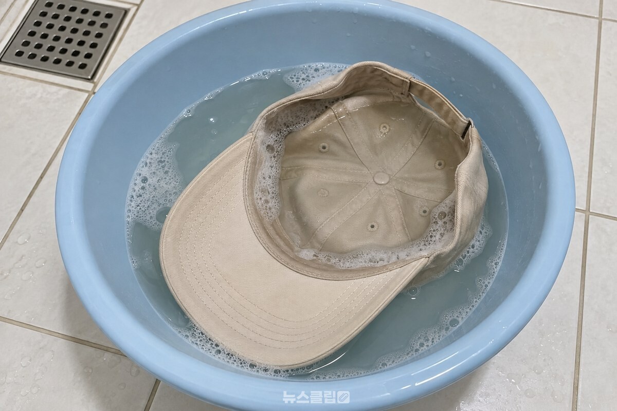 욕실 대야의 샴푸 물에 야구모자를 담가 둔 모습. / 기사 이해를 돕기 위한 생성형 이미지