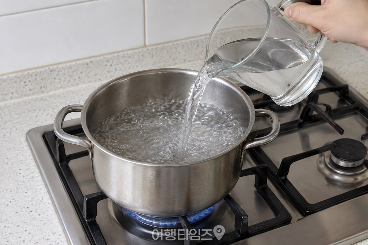 끓어오른 냄비 물에 계량컵으로 찬물을 붓는 장면. / 기사 이해를 돕기 위한 생성형 이미지