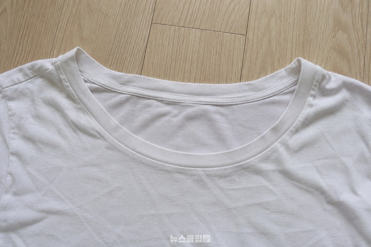 흰 면 티셔츠의 목선이 몸통보다 넓게 벌어진 상태를 가까이 보여 주는 사진. / 기사 이해를 돕기 위한 생성형 이미지