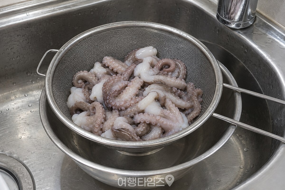 체에 밭친 손질 낙지의 물기가 깨끗한 스테인리스 볼 위로 빠져 있다. / 기사 이해를 돕기 위한 생성형 이미지