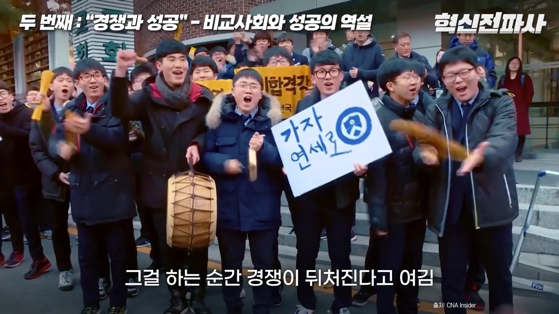 대학 입시 시험장 앞에서 응원하는 학생들의 모습이 담긴 영상 캡처 화면이며, 한 학생이 '가자 연세로'라고 적힌 피켓을 들고 있다.