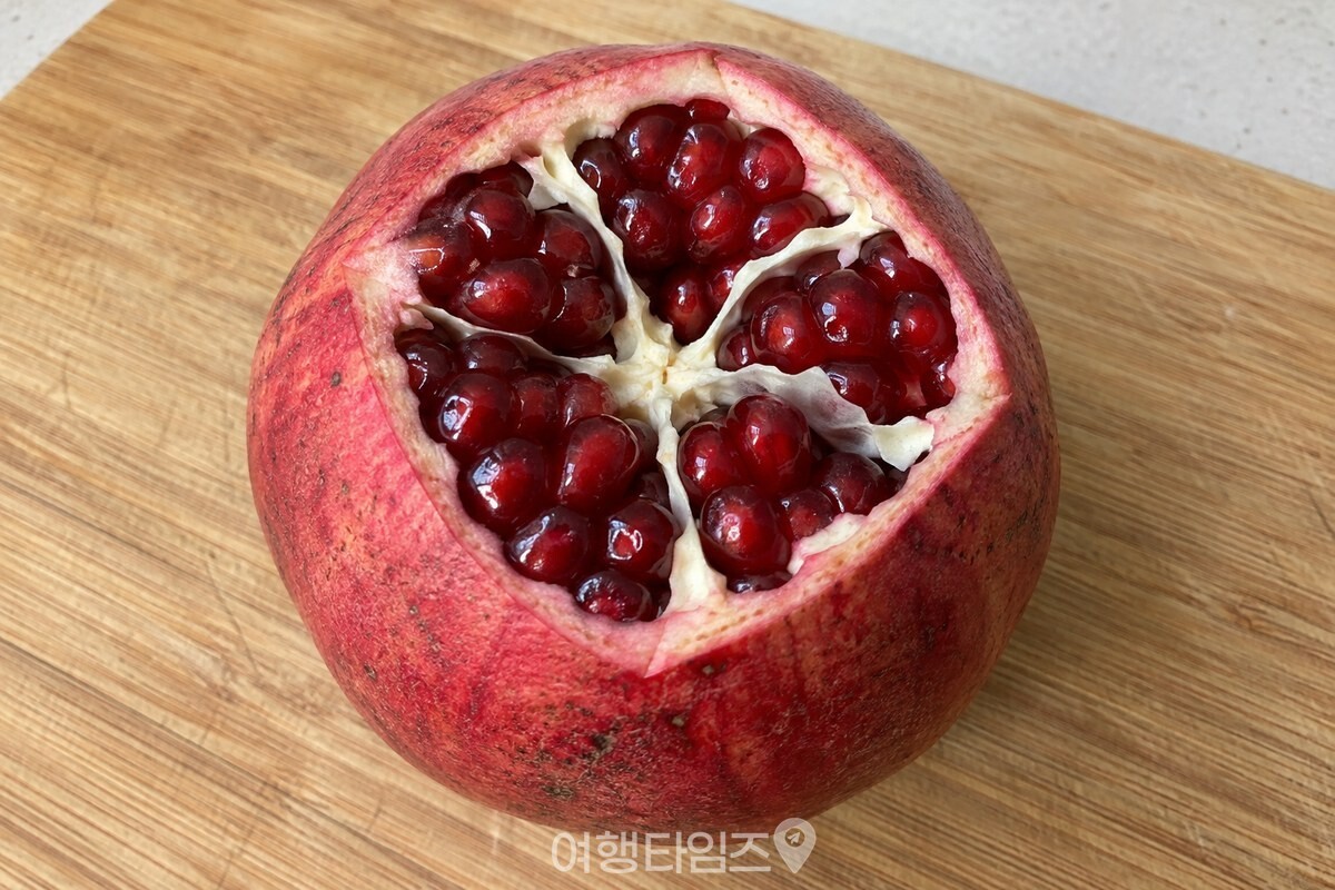 꼭지 쪽을 연 석류 안에 흰 막으로 나뉜 알맹이 칸이 보이는 모습. / 기사 이해를 돕기 위한 생성형 이미지