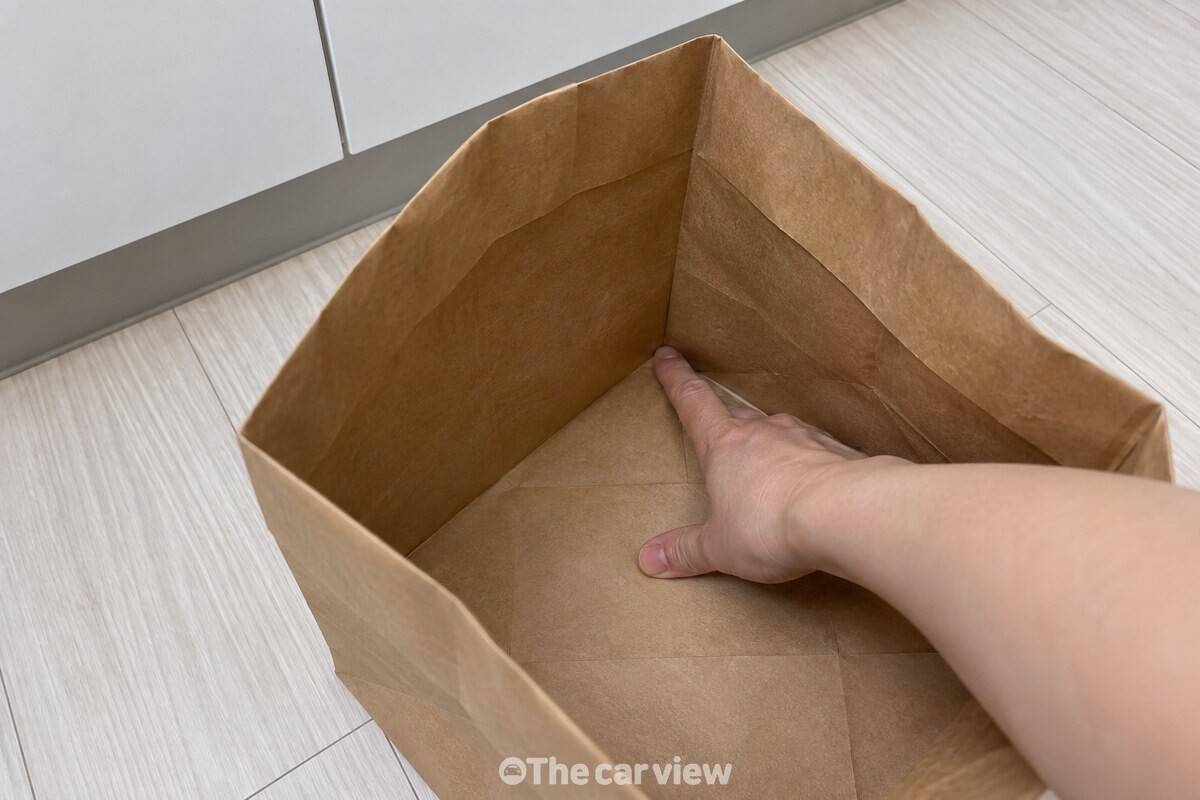 손가락으로 종이봉투의 안쪽 모서리를 눌러 바닥과 옆면의 각을 세우고 있다. / 기사 이해를 돕기 위한 생성형 이미지