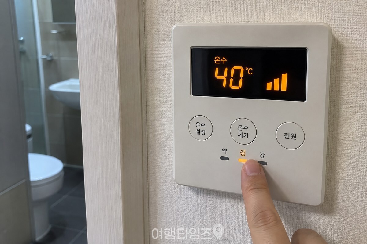 온도조절기의 온수 항목에서 40도로 맞추고 세기를 중간으로 고르는 손. / 기사 이해를 돕기 위한 생성형 이미지