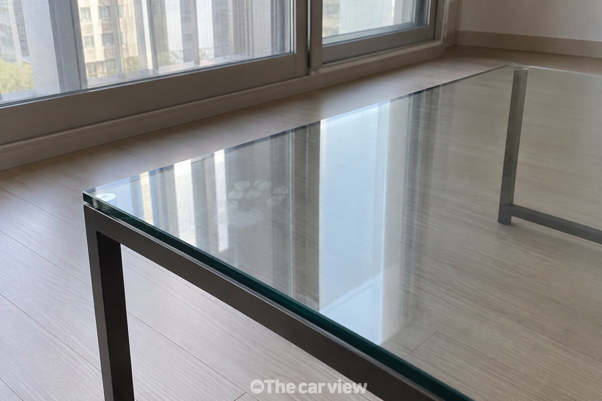 창빛이 비스듬히 비친 유리 상판 한쪽에 옅은 손가락 자국이 보이는 모습. / 기사 이해를 돕기 위한 생성형 이미지