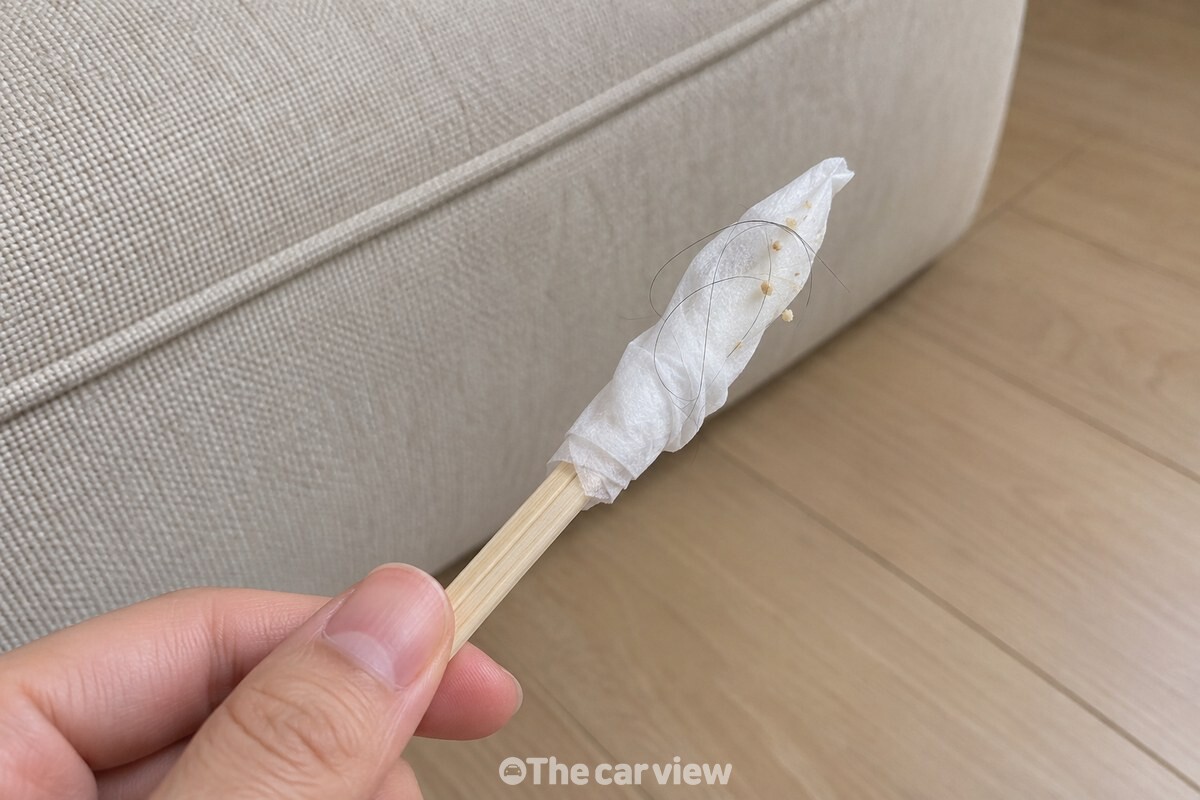 한 겹의 물티슈를 감은 가는 나무젓가락 끝에 머리카락과 작은 부스러기가 붙어 나온 모습. / 기사 이해를 돕기 위한 생성형 이미지