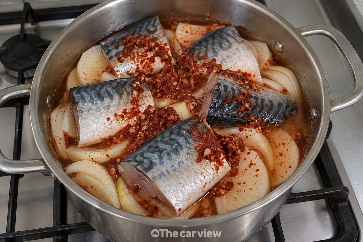 냄비 바닥의 무와 양파 위에 헹군 고등어를 올리고 양념과 물을 더한 조림 준비 모습이다. / 기사 이해를 돕기 위한 생성형 이미지