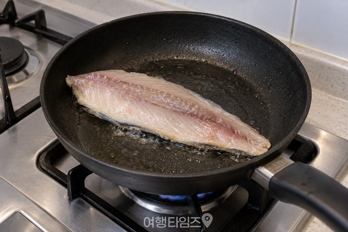 예열한 프라이팬에 고등어를 껍질 쪽부터 아래로 놓고 중약불로 굽는 모습. / 기사 이해를 돕기 위한 생성형 이미지
