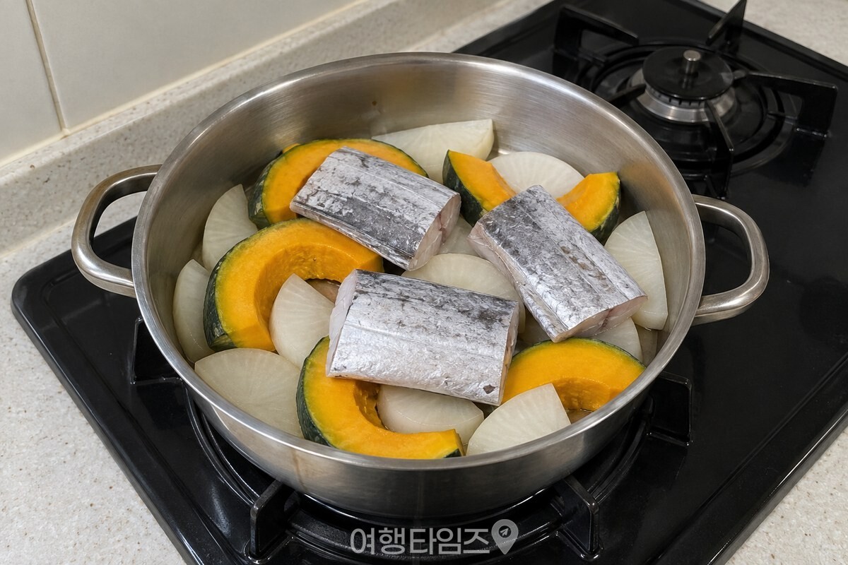 단호박과 무를 한 겹으로 깐 냄비 위에 갈치 토막을 올려 조릴 준비를 한 모습. / 기사 이해를 돕기 위한 생성형 이미지