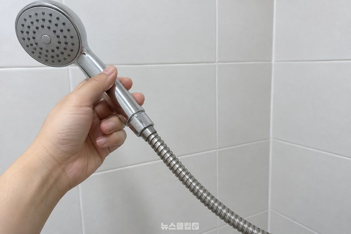 주름진 샤워기 호스 표면과 헤드 연결부를 가까이에서 본 모습. / 기사 이해를 돕기 위한 생성형 이미지