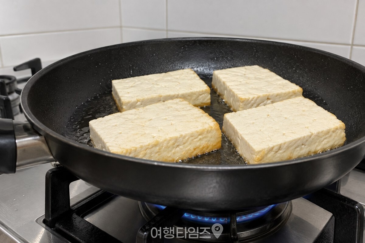 프라이팬 한쪽에서 움직이지 않은 채 노릇해지는 두부의 아래쪽 테두리. / 기사 이해를 돕기 위한 생성형 이미지