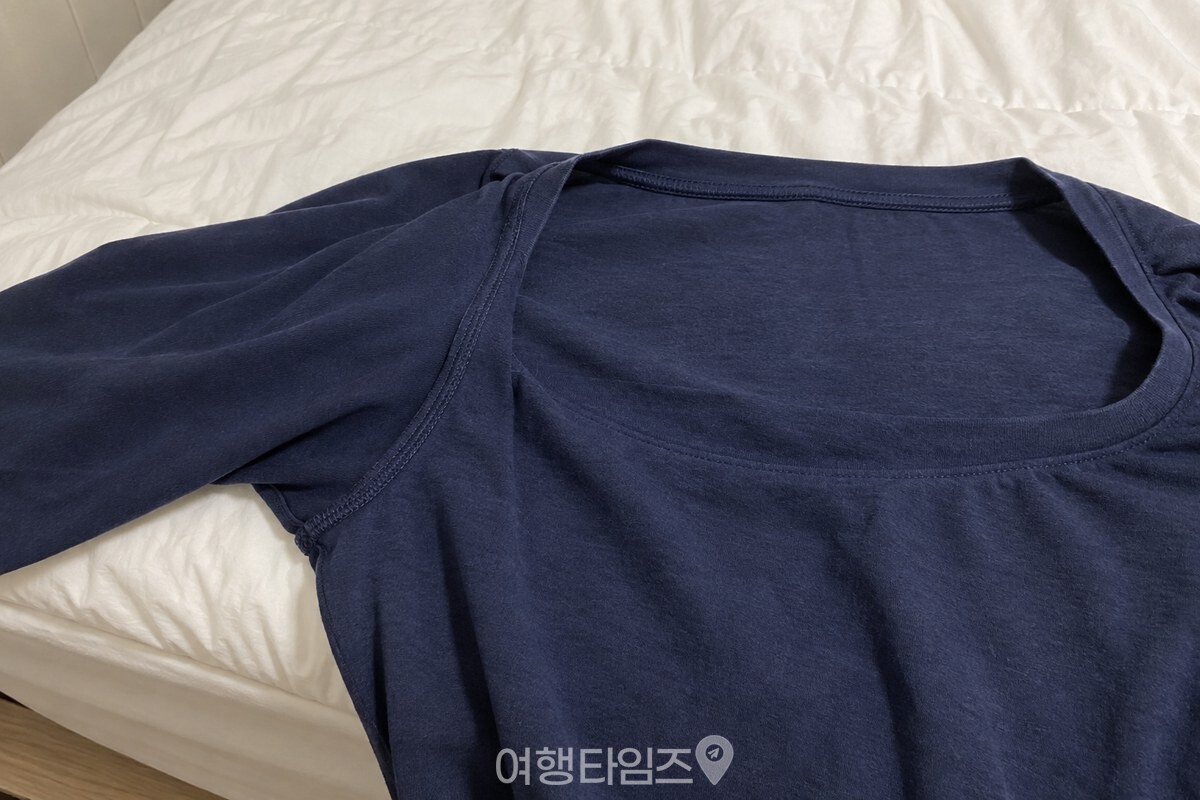 침대 가장자리에 펼쳐 둔 면 잠옷의 목덜미 안쪽과 겨드랑이 봉제선이 보이는 가까운 모습. / 기사 이해를 돕기 위한 생성형 이미지