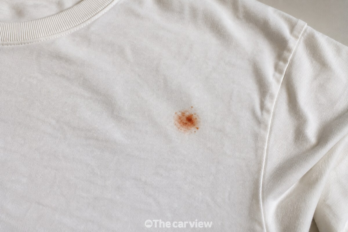 밝은색 면 셔츠에 남은 작은 붉은 자국과 섬유 결을 가까이서 보여 주는 모습. / 기사 이해를 돕기 위한 생성형 이미지