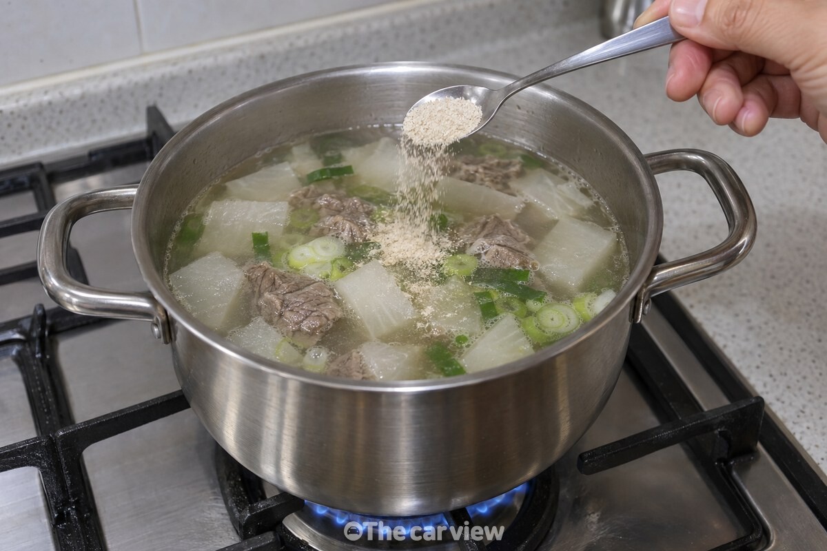 불을 끄기 직전 뭇국 위에 건새우가루를 반 스푼 넣는 모습이다. / 기사 이해를 돕기 위한 생성형 이미지