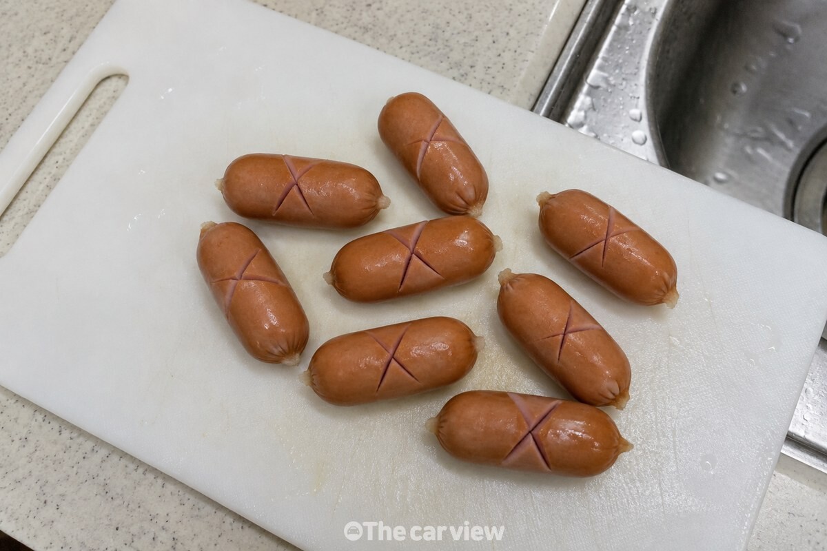 도마 위 비엔나소시지 가운데에 얕은 십자 칼집을 낸 모습. / 기사 이해를 돕기 위한 생성형 이미지